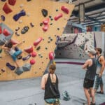 A group of friends watching a woman bouldering indoor