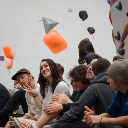 Group of people sitting on the floor at bouldering centre