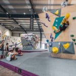 A group of people climbing on a bouldering wall in Easton.