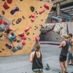 A group of people watching a woman boulder