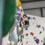 An indoor climber scaling a climbing wall in Easton.