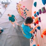 Child practising climbing skills on colourful holds during a coached session at Flashpoint Easton