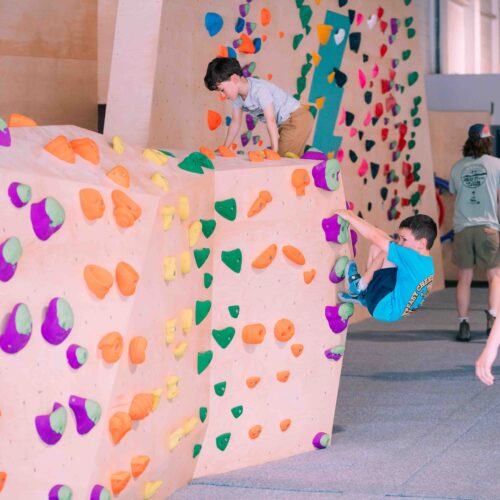 Young climbers practising on colourful holds at Flashpoint Easton